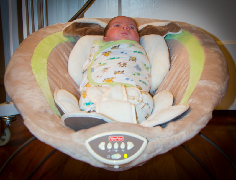 baby boy max sits swaddled in a My Little Snugabunny Baby Bouncer, shot from the foot angle, reminiscent of the Captain Kirk's chair in the original Star Trek.