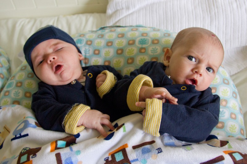 twin baby boys, max and sam, wearing matching navy blue Gap clothes sing an opera aria duet while sitting on a Boppy Baby Lounger