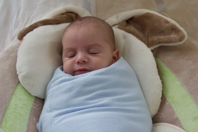 baby boy sam sleeps in a light blue Summer SwaddleMe blanket, sitting in a Fisher Price My Little Snugabunny Cradle and Swing