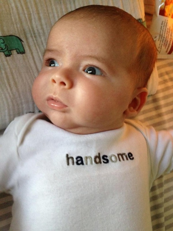 baby boy max wearing a white onesie that says 'handsome'