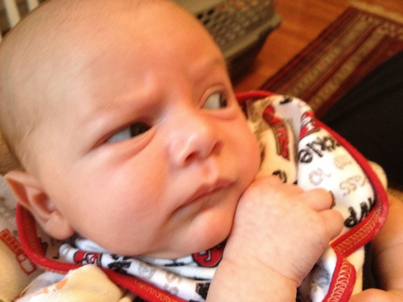 baby boy sam, close-up, draws his closed fist close to his chin