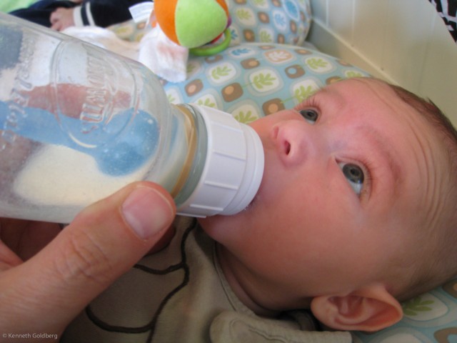 baby boy sam drinks milk from a Dr. Brown's bottle