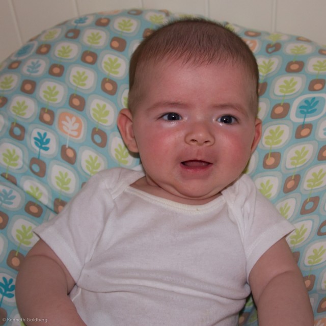 baby boy max, sits on a BoppyNewbornLounger wearing a white onesie