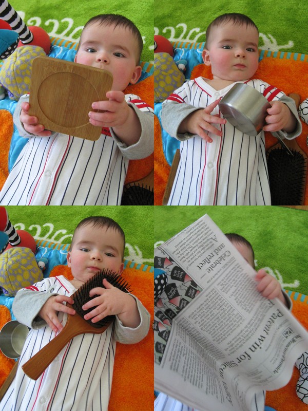 baby boy max with a bamboo coaster, a stainless steel measuring cup, a wooden hairbrush, and The San Francisco Chronicle newspaper