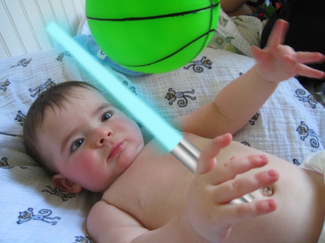 baby box max holds a light saber battling a green ball