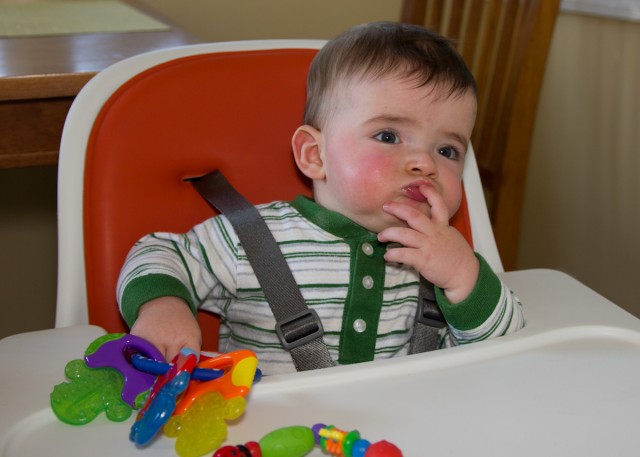 baby boy max sits in a highchair thinking deeply