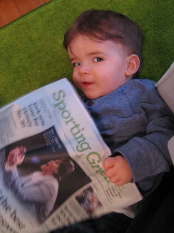 baby boy max looks coy as he read the San Francisco Chronicle Sporting Green